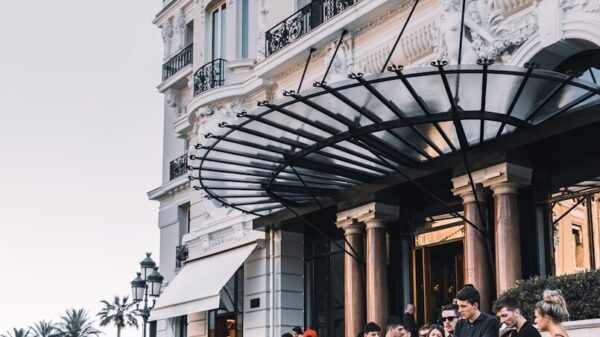 yellow sport car parked on street surrounded group of people