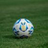 Close-up of a soccer ball on a grassy field, perfect for sports-themed designs.
