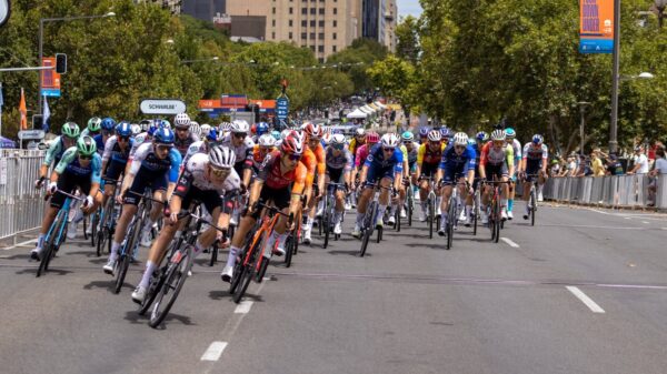 Competitive cyclists race in Adelaide, showcasing intense action and team spirit under the summer sun.