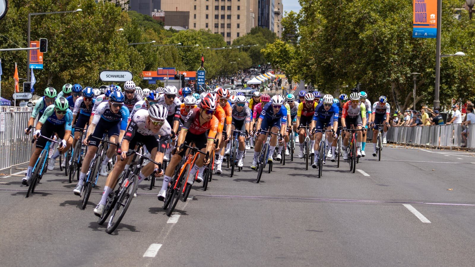 Competitive cyclists race in Adelaide, showcasing intense action and team spirit under the summer sun.
