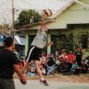 man in white crew neck t-shirt and black shorts holding yellow volleyball