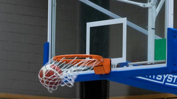 Close-up of a basketball scoring through the hoop in an indoor court setting.