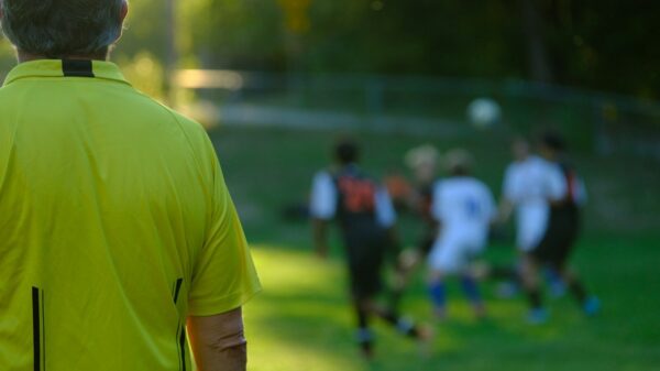 a man looking at a group of people on a field