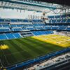 Aerial view of ongoing renovation at Santiago Bernabéu Stadium in Madrid, showcasing construction and vibrant seating arrangement.