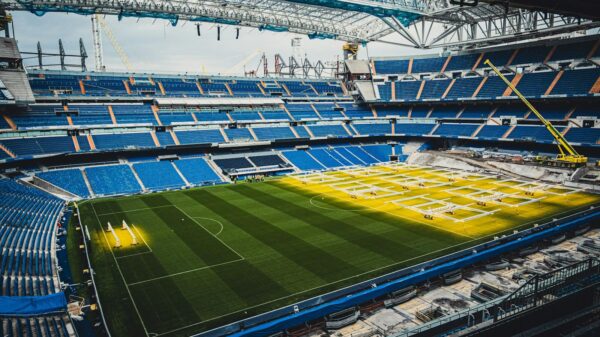 Aerial view of ongoing renovation at Santiago Bernabéu Stadium in Madrid, showcasing construction and vibrant seating arrangement.