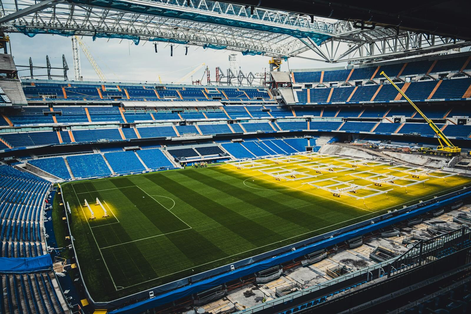 Aerial view of ongoing renovation at Santiago Bernabéu Stadium in Madrid, showcasing construction and vibrant seating arrangement.
