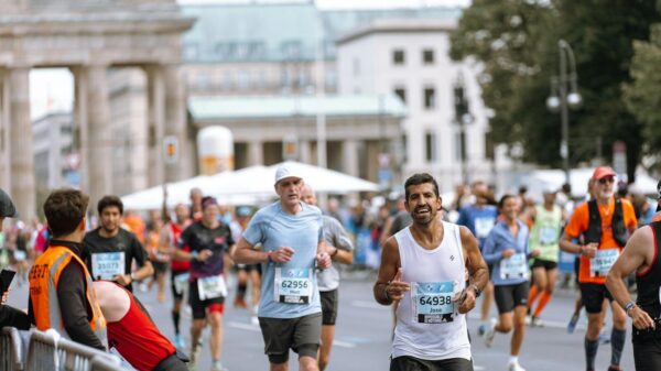 Runners cross finish line at Berlin Marathon, showcasing athletic determination.