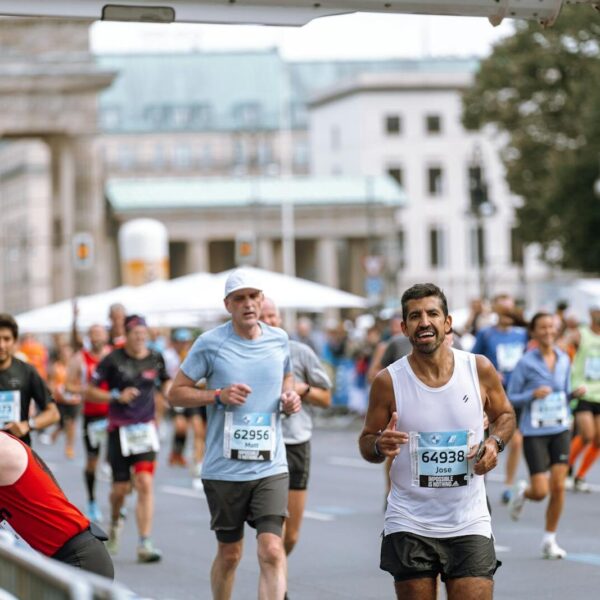 Runners cross finish line at Berlin Marathon, showcasing athletic determination.