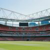 A view of the empty Emirates Stadium, home of Arsenal FC, under a clear sky in London.
