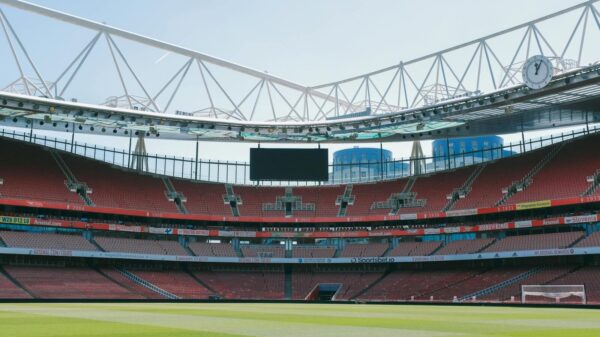 A view of the empty Emirates Stadium, home of Arsenal FC, under a clear sky in London.