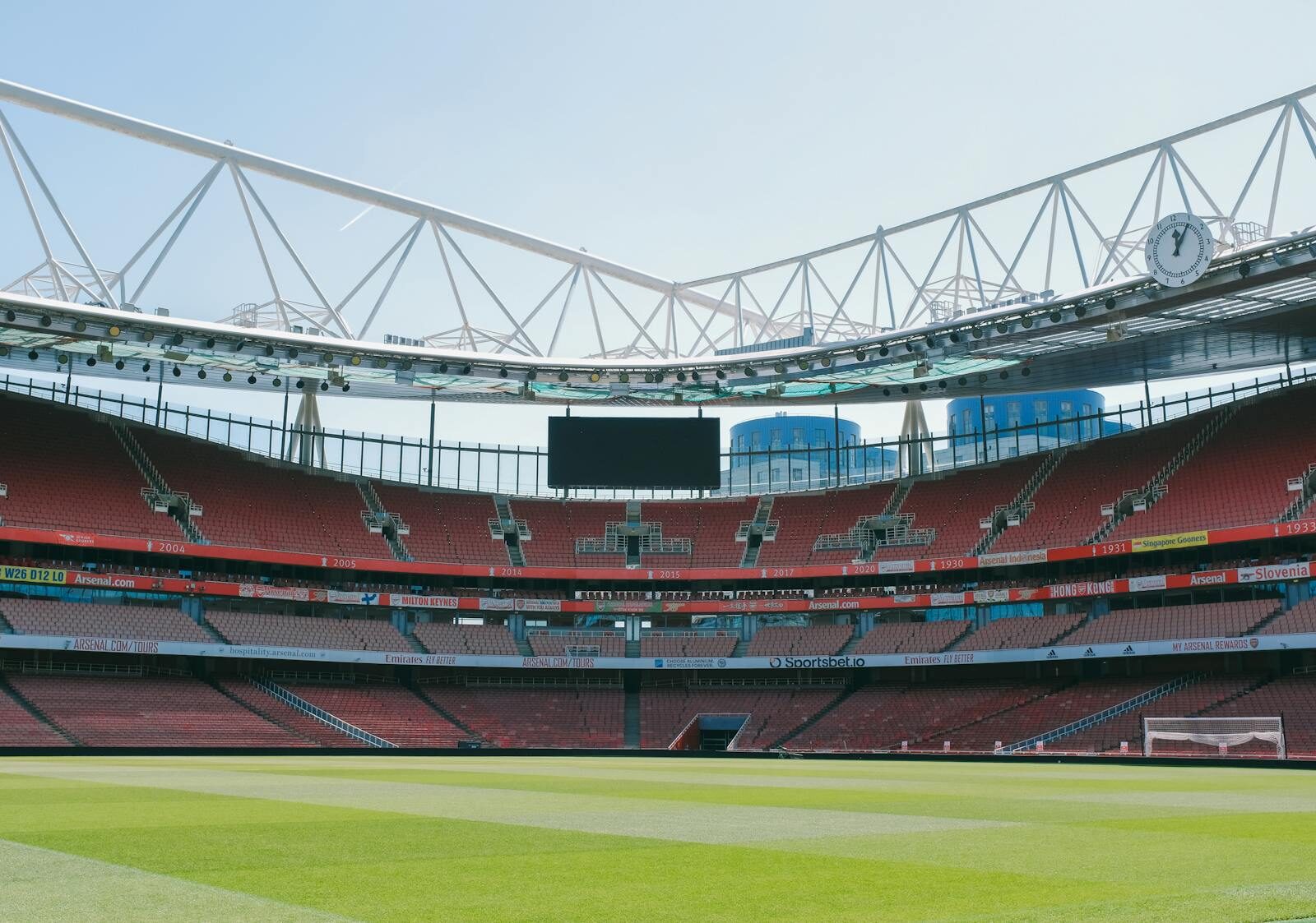 A view of the empty Emirates Stadium, home of Arsenal FC, under a clear sky in London.