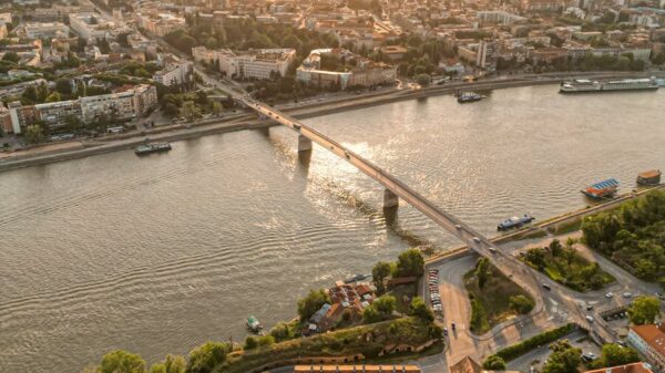 Stunning aerial view of a cityscape with a central river and a bridge at sunset.