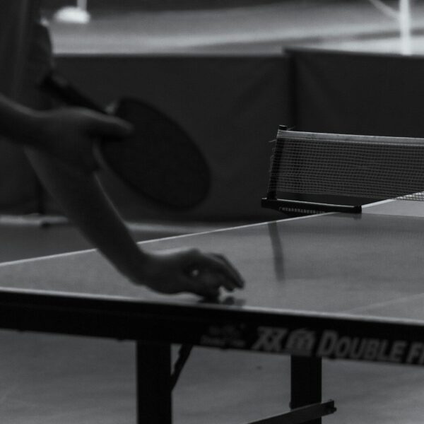 Person playing table tennis with a paddle.