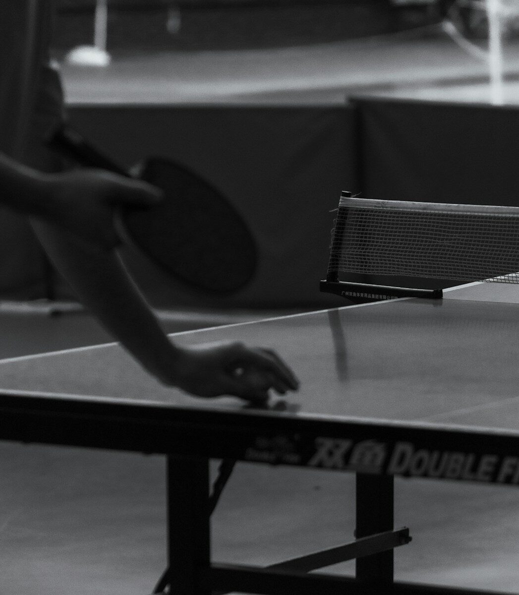 Person playing table tennis with a paddle.
