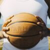 Person holding a basketball outside in Rabat, Morocco, under sunny conditions, symbolizing sports culture.