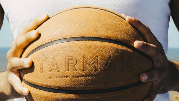 Person holding a basketball outside in Rabat, Morocco, under sunny conditions, symbolizing sports culture.
