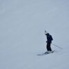 A skier navigating a snowy slope, showcasing winter sports and seasonal recreation.