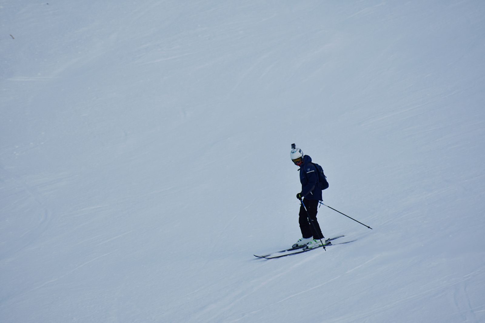 A skier navigating a snowy slope, showcasing winter sports and seasonal recreation.