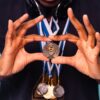 Close-up of an athlete holding medals, symbolizing victory and achievement in sports.