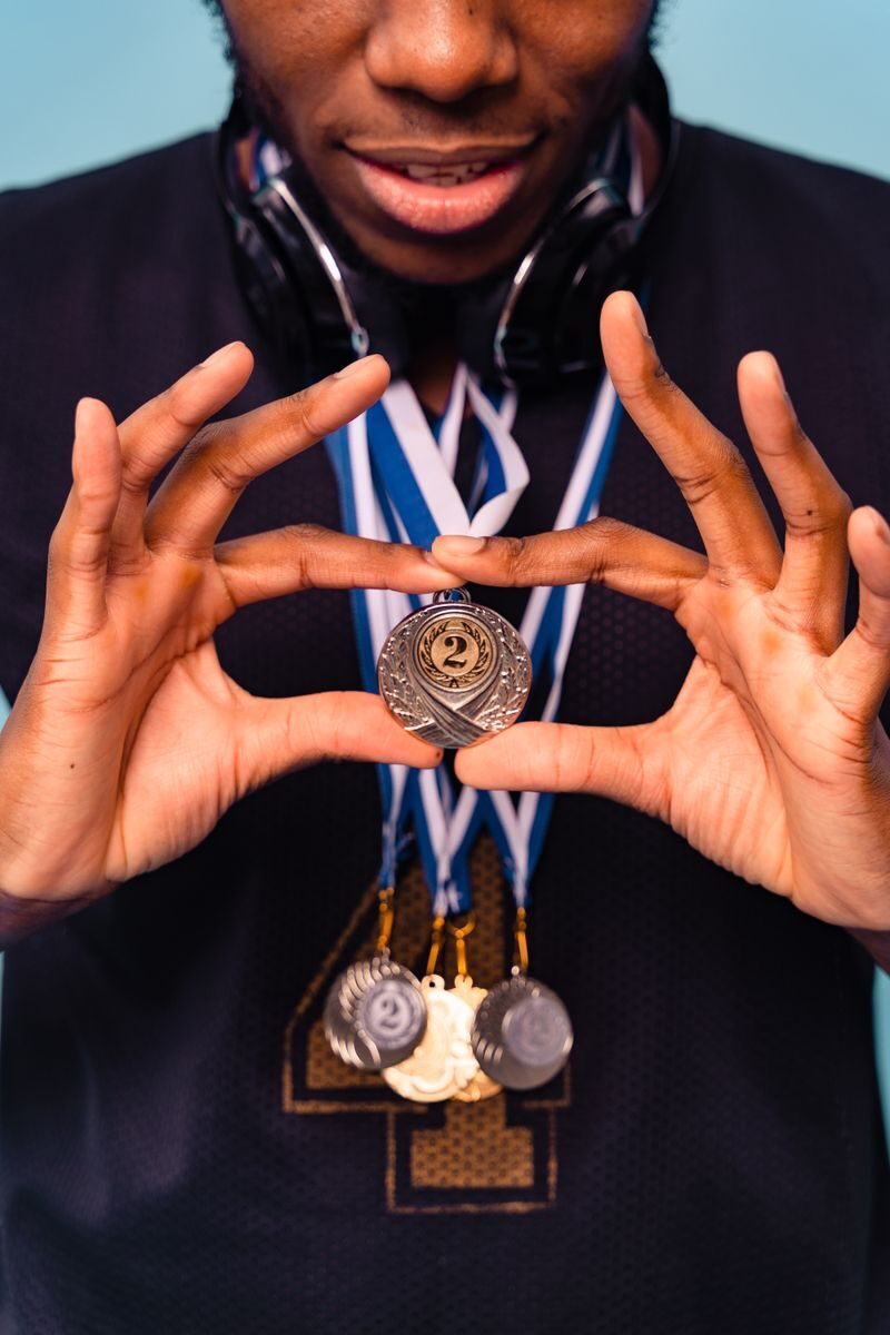 Close-up of an athlete holding medals, symbolizing victory and achievement in sports.