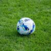 A detailed view of a soccer ball resting on a lush green grass field.