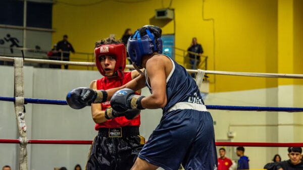 Two athletes engaged in a competitive boxing match, showcasing skill and determination.