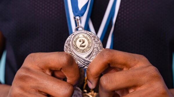 Close-up of hands holding a silver medal showcasing achievement and recognition.