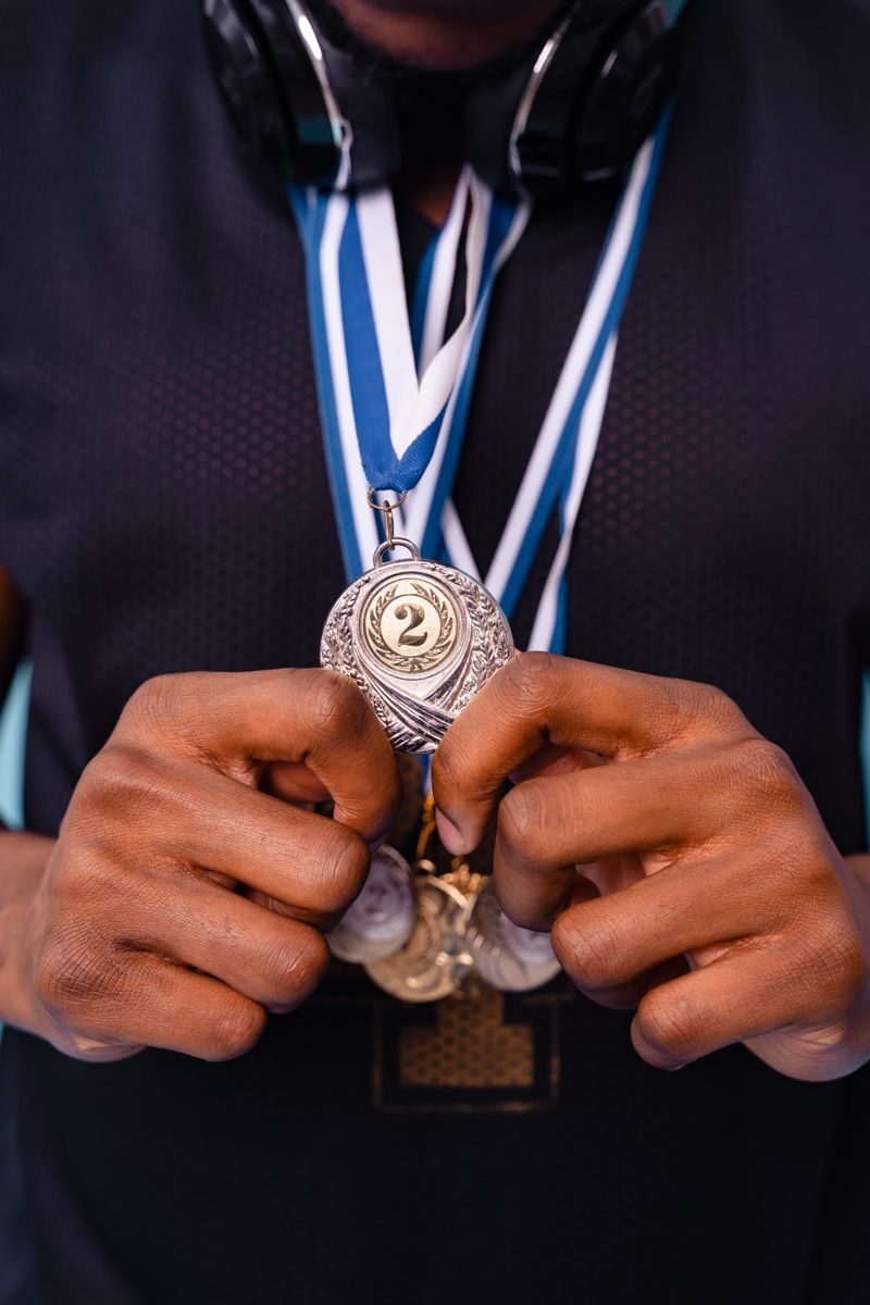 Close-up of hands holding a silver medal showcasing achievement and recognition.