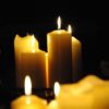 Cozy ambience with close-up of flickering candles on a dark background.